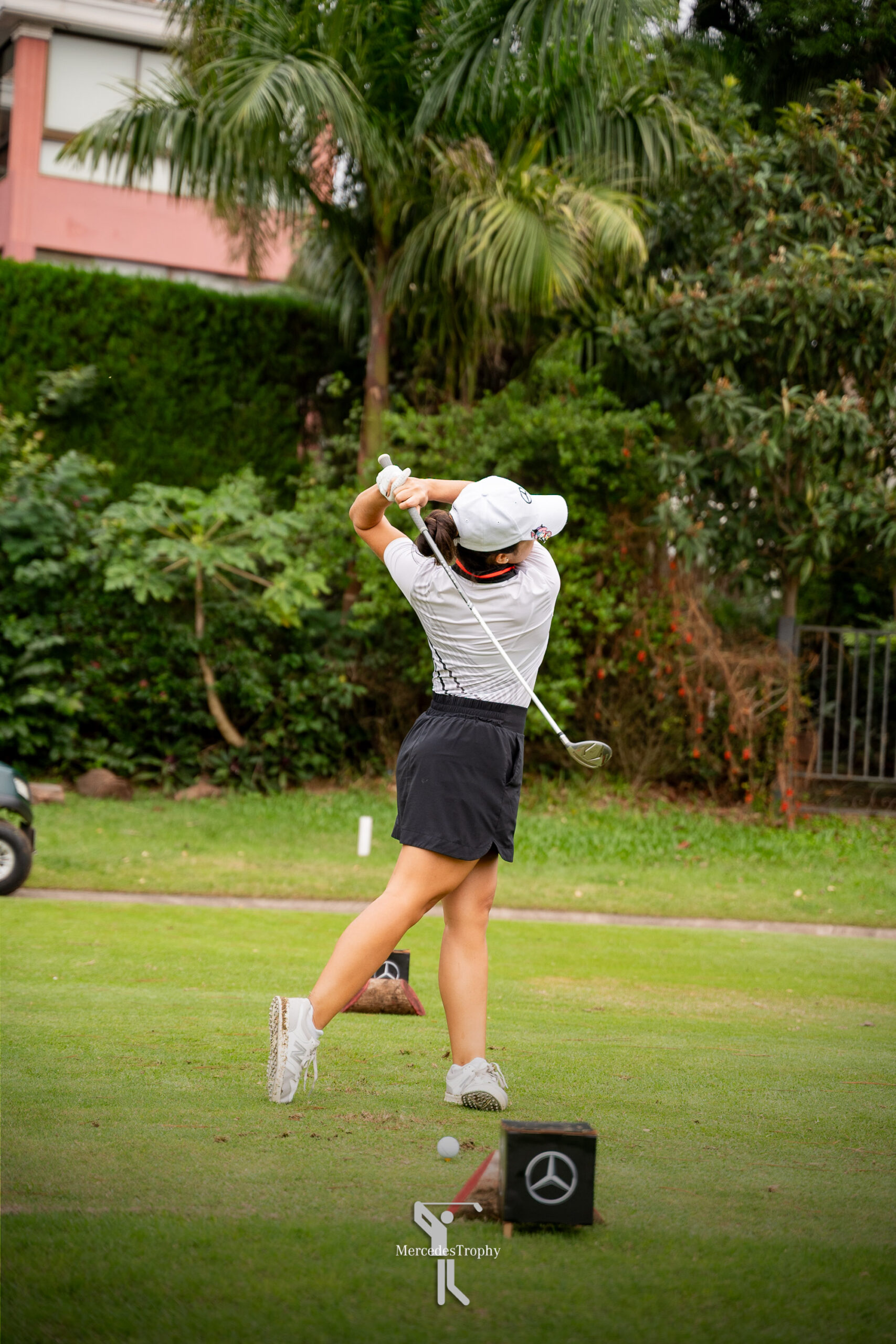 Jugadora realiza su swing en plena competencia del MercedesTrophy, con vegetación de fondo.